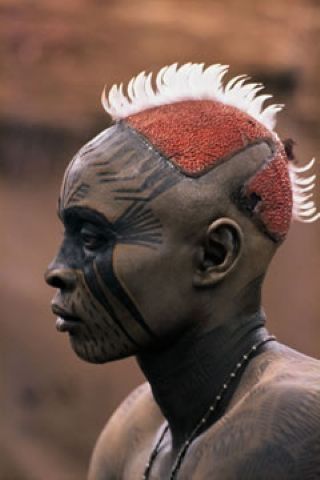 Africa | A Nuba from Kau with his painted face mask.  Sudan.  Featured in the 19