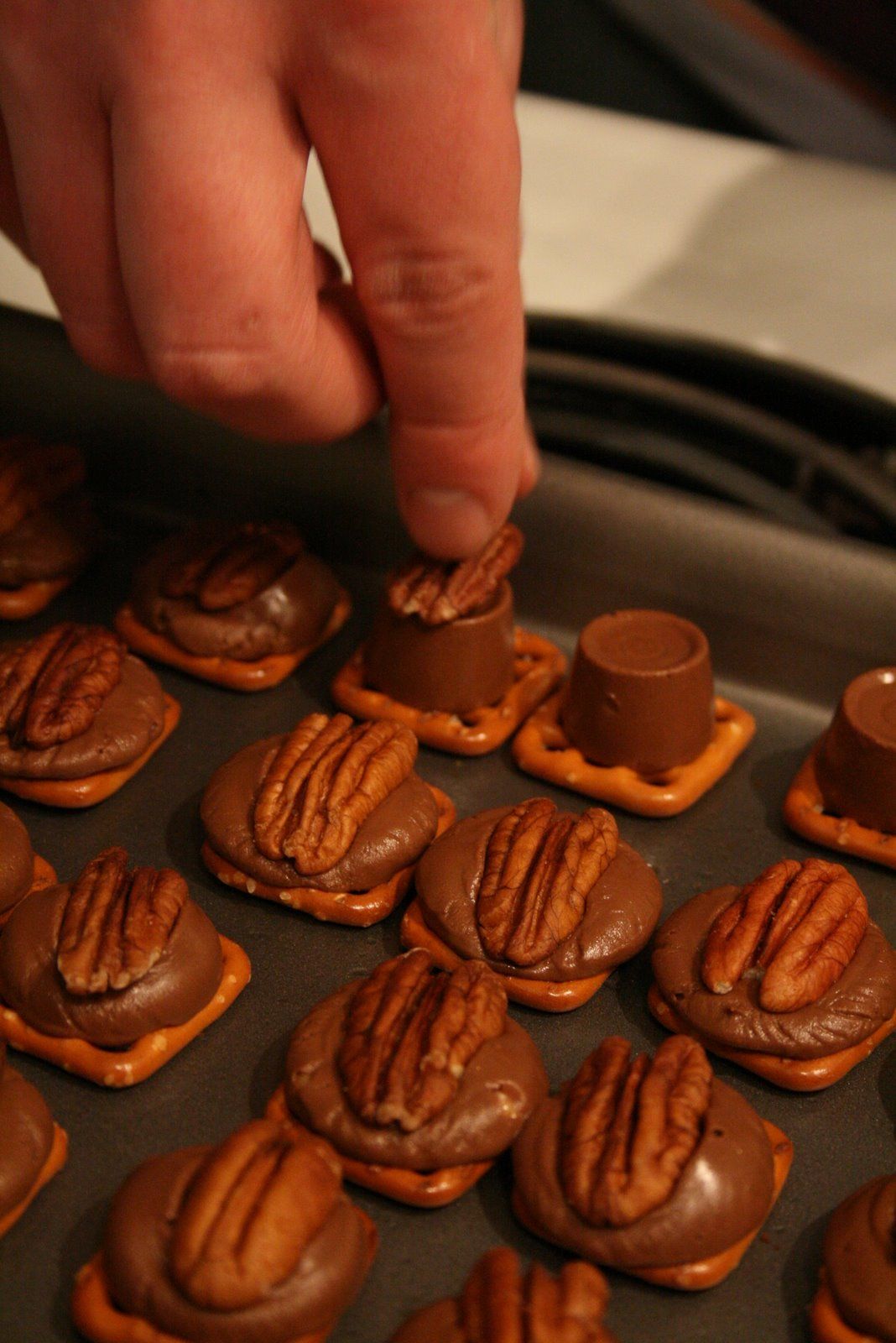 Rolo TURTLES.—a square pretzel, Rolo candy piece, half a pecan and the oven is