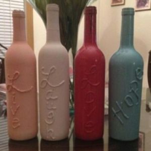 Take old wine bottles, use hot glue gun to write & then spray paint over it.