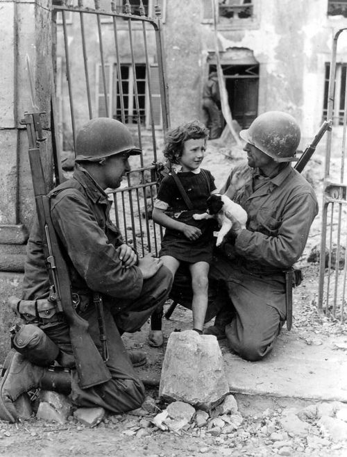 American GI's try to cheer up a little girl after the invasion of Normandy