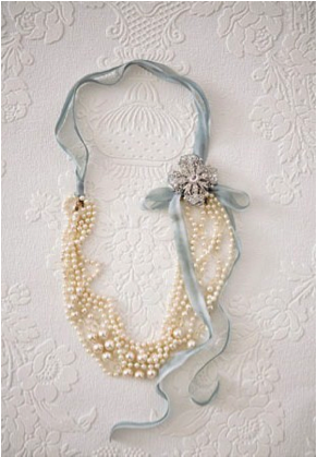 For this classy necklace, fold a long pearl necklace in half and tie ribbon arou