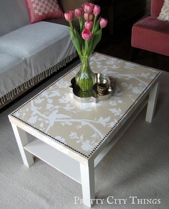 Buy a $20 dollar IKEA plain white coffee table. Pick your wallpaper print, spray