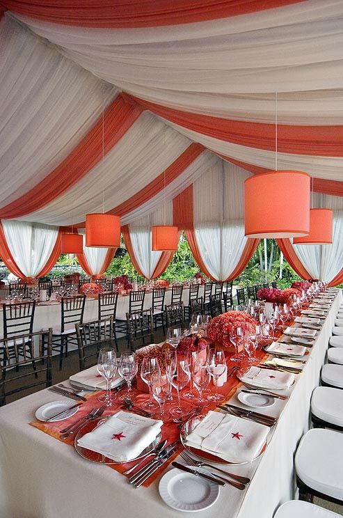 Coral and orange table runners and centerpieces add a splash of color to crisp w