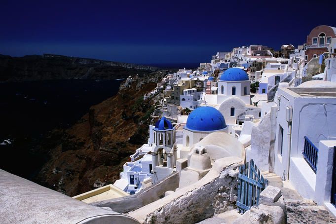 Greek Islands. White-washed houses and blue domes on cliff top.