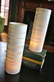 Simply get a plain glass vase, wrap rubber bands around it, spray paint it, and