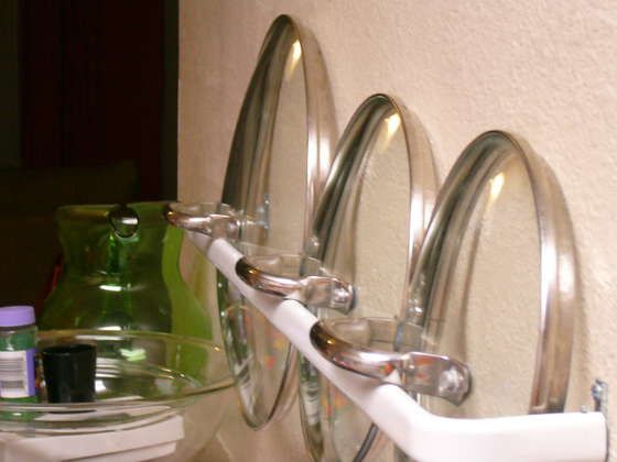 Use curtain rods on the inside of cabinet doors to hold your pot lids!