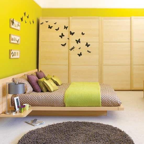Yellow bedroom. I love the butterfly decals flying from the wardrobe to the wall
