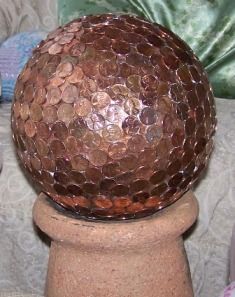bowling ball covered with pennies – pretty and helps prevent slugs…