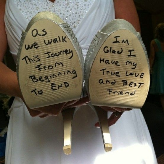 the groom writes on the brides shoes before the wedding