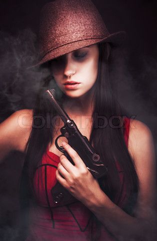 Stock image of 'Sexy woman mobster with her hat pulled low over her eyes tot