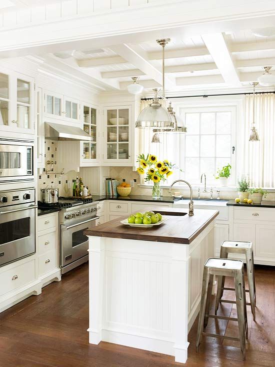 white kitchen + wood-topped island + stainless