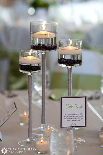 Floating candle centerpiece with 3 small flower pieces in greens and whites arou