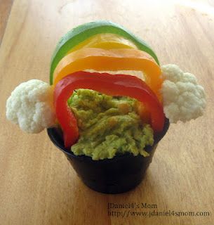 St. Patrick’s Day Snack of Spinach Hummus under a rainbow of colored peppers.