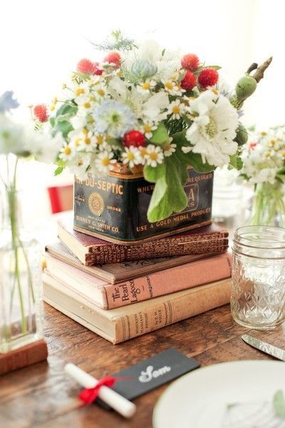 Books,  glass, vintage tins and flowers.  Love this idea for a centrepiece — bo