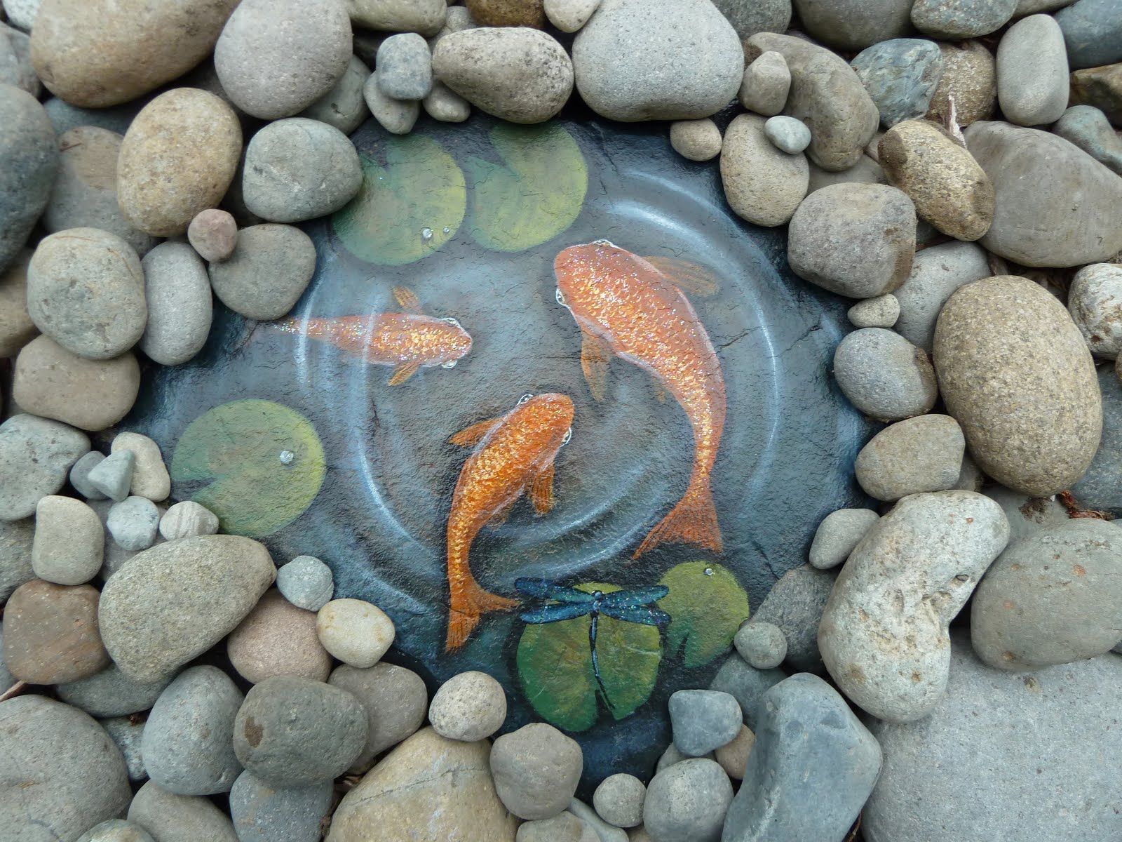 Water scene painted on slate, surrounded by river rock, looks cool!