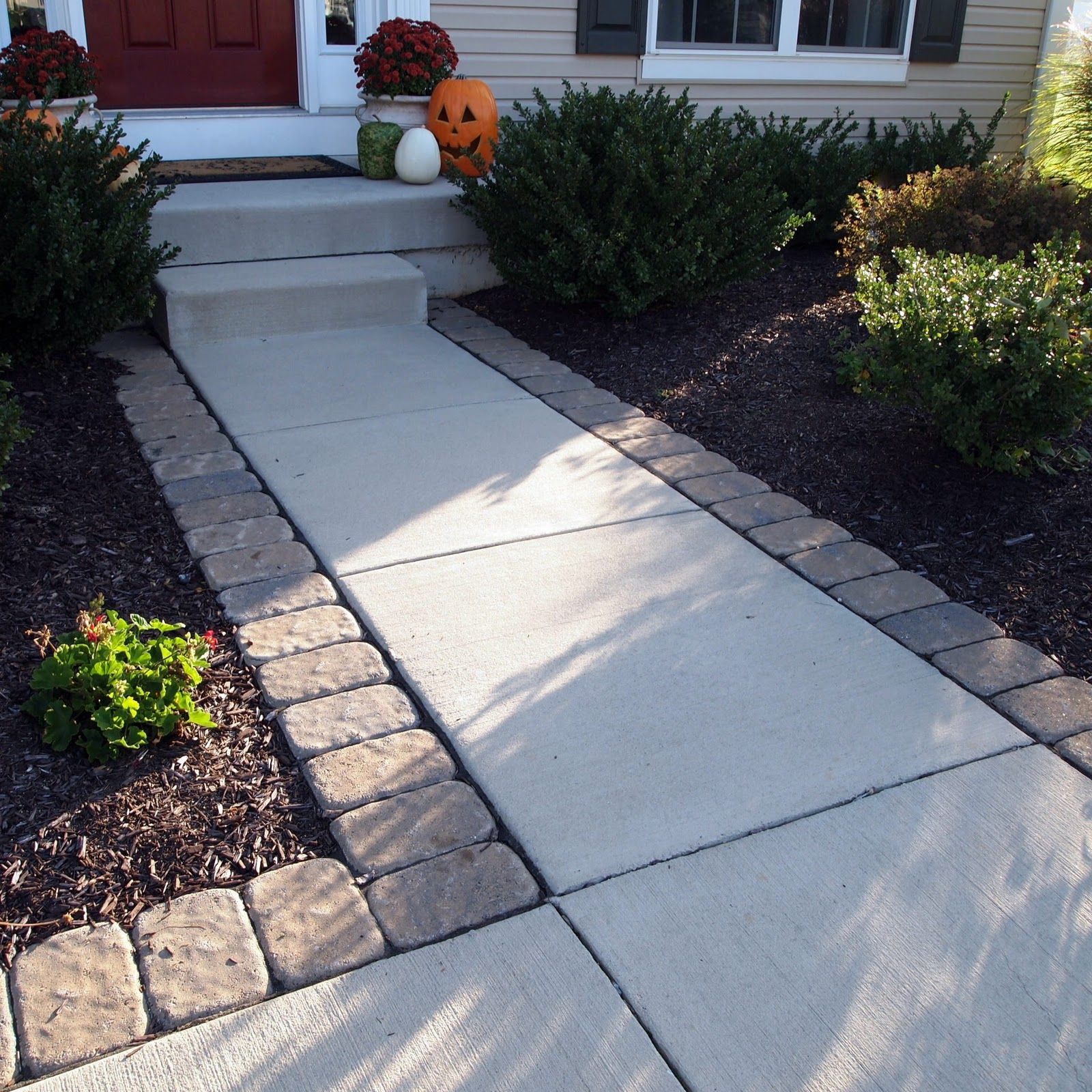 Adding pavers around a standard concrete walkway can give your entrance a little