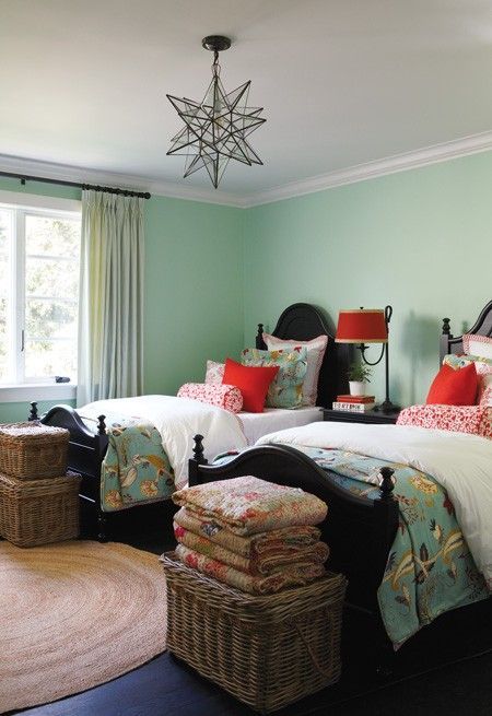 Love this room; the wall color…. the old beds painted black, basket trunks.