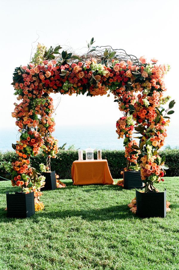 Orange and coral wedding ceremony alter decor, photo by Yvette Roman Photography