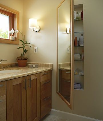 Carve out storage space between wall studs and use a mirror as a door.  SUCH a g
