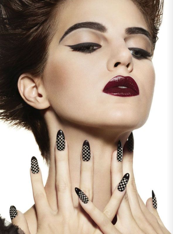 Gorgeous winged eyeliner, heavy brow, dark bold lip with checkered nails.