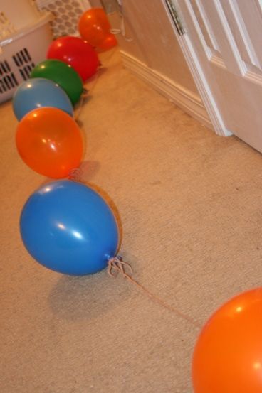 A trail of balloons leading from the bed to the birthday gift when the birthday
