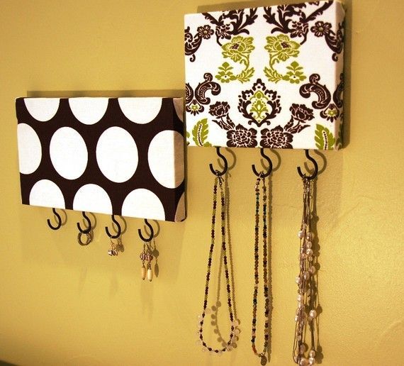 take a piece of wood, cover it w/ fabric, add hooks…so easy and oh so cute