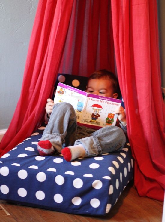 Use your old crib mattress for an upcycled reading nook and attach curtains to a