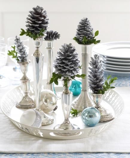 Top silver candlesticks with silvery painted pinecones for an elegant centerpiec