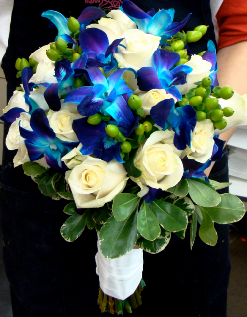 Blue flowers wedding bouquet with blue orchids and white roses and green leaves.