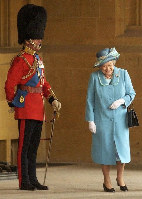 Queen Elizabeth laughing as she passes her husband, Prince Philip, Duke of Edin