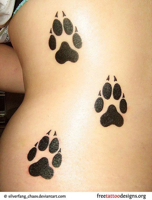 Wolf paw prints tattoo on a womans back, cute but should be dog paw prints on si