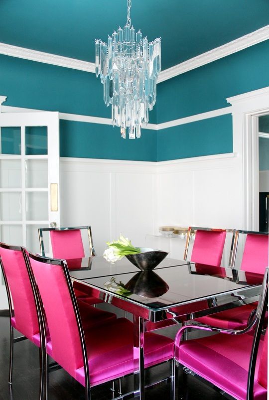 White molding and a bold wall color, crystal chandelier and a metal dining table