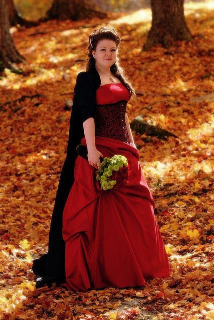 Lovely red wedding dress among the autumn leaves…