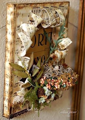 A beautiful altered canvas with sheet music, faux greenery and a “birds nest.” A
