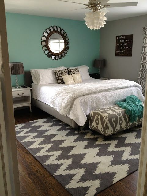 Bedroom with gray upholstered platform bed & headboard, white bedside tables a g