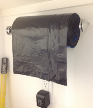Use a paper towel holder to put your roll of garbage bags on it. Makes it very e