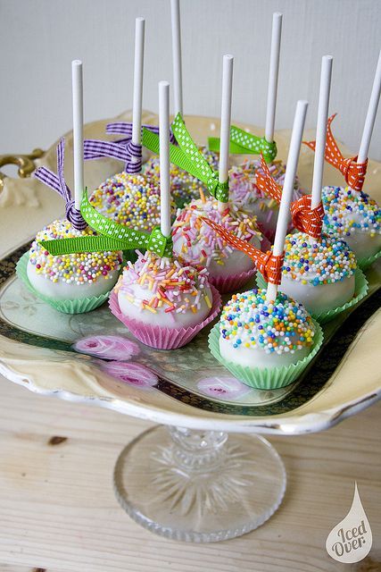 White Cake Pops with Multi-Color Sprinkles and Ribbon in Purple, Green & Orange