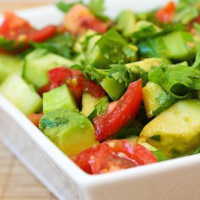A fresh summer side dish: tomato, avocado, cucumber salad with cilantro in lime
