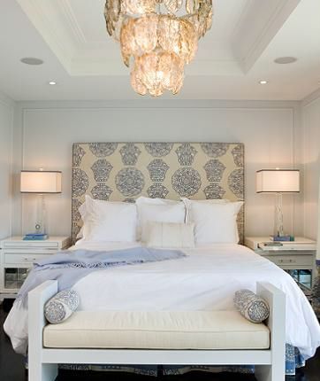 A gorgeous blue and white master bedroom. The focal point is the upholstered hea