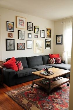 printed carpet, red accents, dark grey couch, wall of frames, gallery, industria
