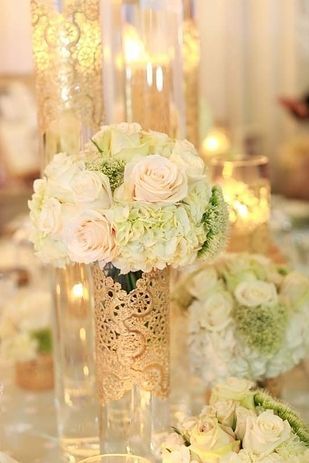 Tall clear vases with gold doilies.