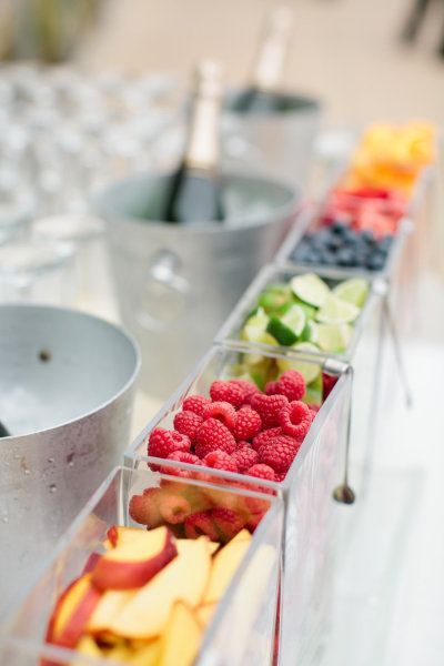 Raspberries, peaches, limes, and other fruit garnish for the mimosa bar. Cute idea!