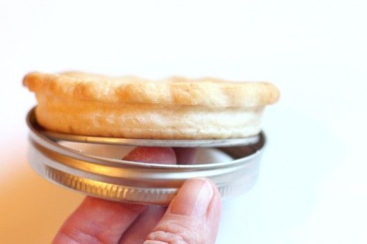 So Clever!  Make mini pies in 2 piece mason jar lids.  The flat lifts crust up and out for easy removal  — like a 2 pc tart pan!   Shown is removing pie crust from mason jar