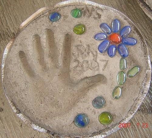Stepping stone with handprint, flat marbles from Dollar Store, made in disposable aluminum pan used as