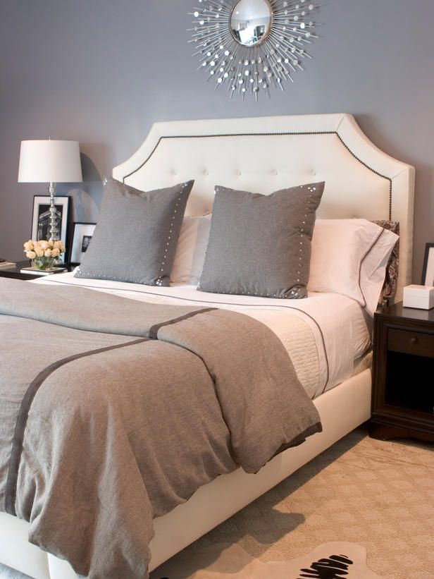 Guest Room – Glamorous Gray. A neutral, tufted and nail-studded headboard stands out against gray walls and bedding. Accessories are kept to a minimum, allowing the bed to take center