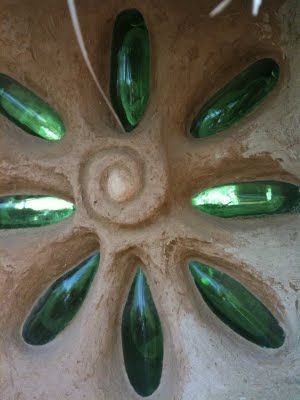 Lotus window made from wine bottles set in a straw bale