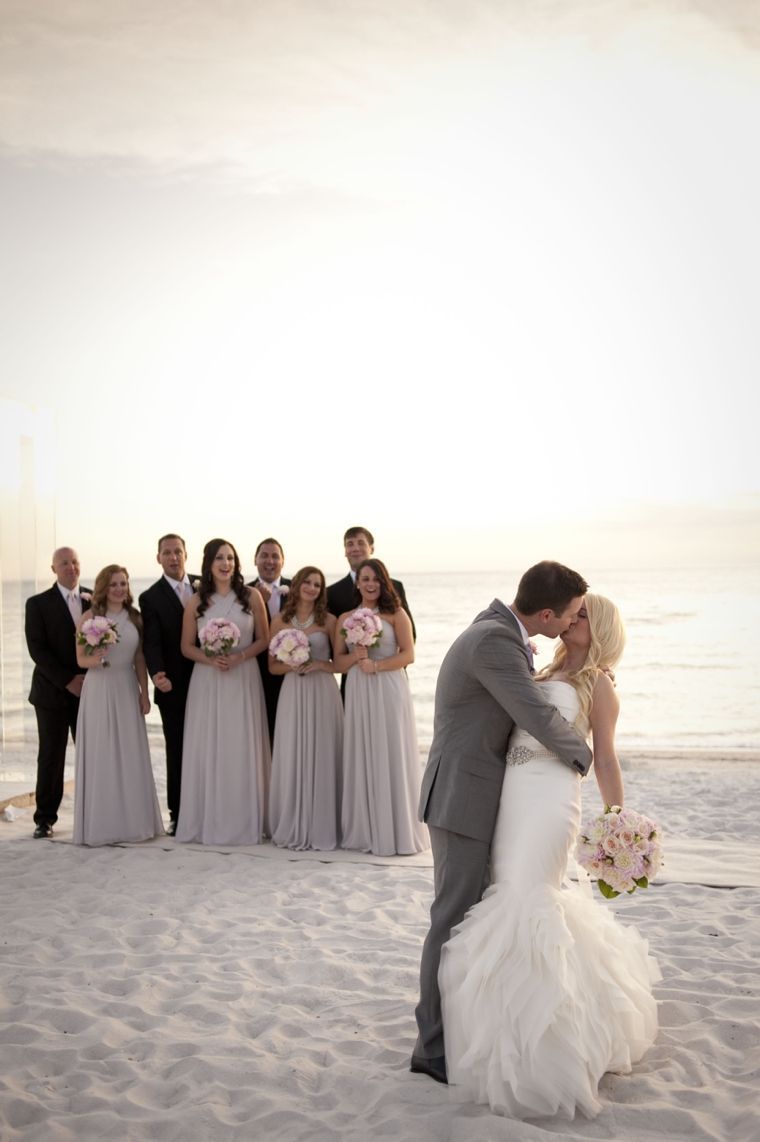Beach wedding photo with the bridal party looking on