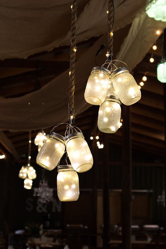 Clusters of frosted LED mason jar lights hung from the ceiling at this rustic barn wedding. So gorgeous and