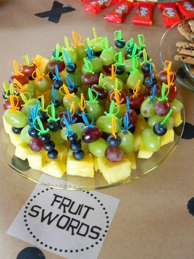 display of fruit for pirate party, really cute idea to use tiny swords for fruit kabobs for pirate party