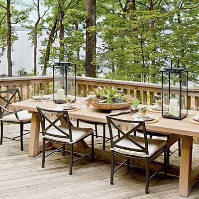 Lake House Decorating Ideas: Set a Rustic Table  Pair a wood table with iron chairs for rustic lakeside dining. Fill hurricanes with river rocks and pillar candles of varying height for a touch of
